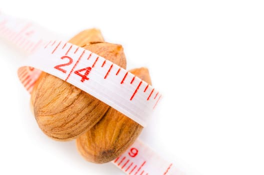 Almond nut and measure tape on white background, food for control weight concept.