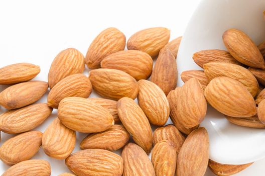 Almond in white bowl on white background.