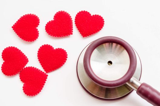 Red heart and a stethoscope on white background.