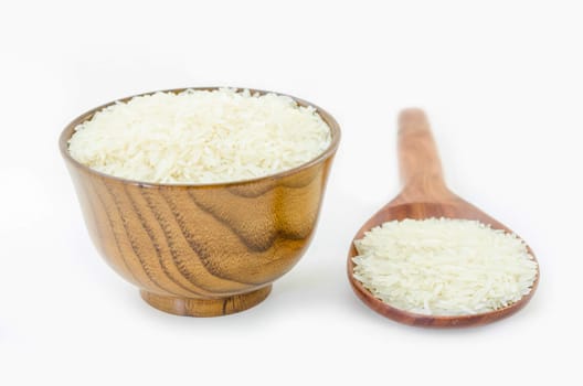 Raw rice in wooden bowl and spoon on white background.
