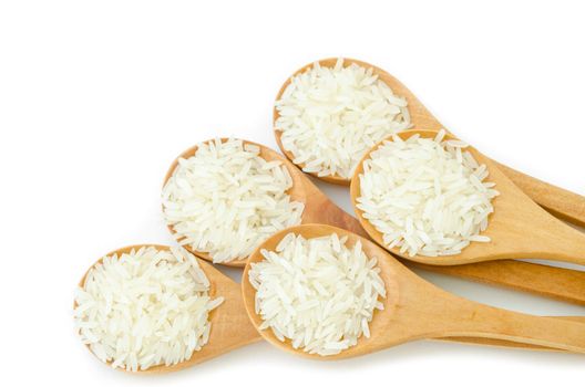 Raw rice in wooden spoons on white background.
