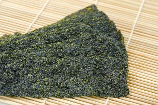 Fried seaweed on bamboo mat background.