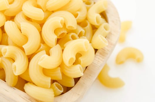 Raw dry elbow macaroni. Italian Pasta raw food in wood bowl on white background.