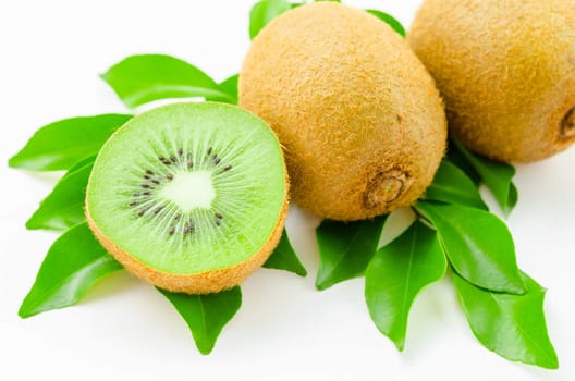 Fresh kiwi fruit with green leaves on white background