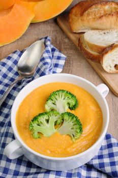 Pumpkin soup puree with cream in a dish with broccoli