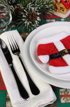 Fragment of the Christmas table serving coat of Santa Claus with cutlery