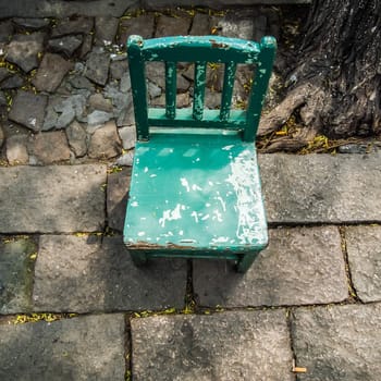 old grunge small green wooden chair in the village