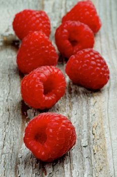 Arrangement of Perfect Ripe Raspberries closeup on Rustic Wooden background