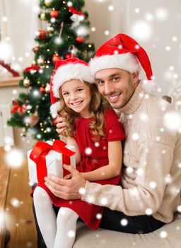 christmas, holidays, family and people concept - smiling father and daughter holding gift box and hugging at home