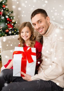 christmas, holidays, family and people concept - smiling father and daughter holding gift box at home