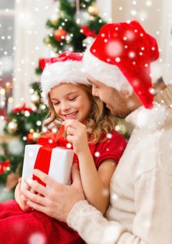 christmas, holidays, family and people concept - smiling father and daughter holding gift box and hugging at home