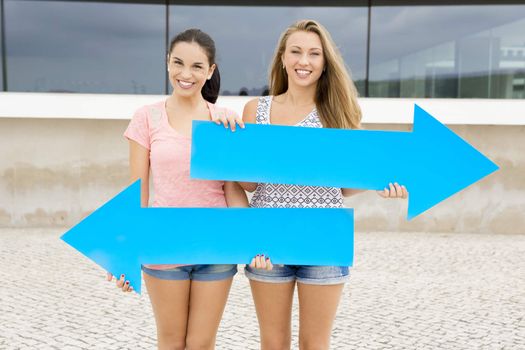 Teenage students holding blue arrows and pointing in diferent directions