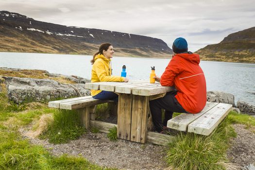 A couple resting close to a beautiful lake