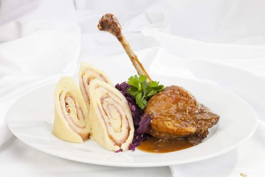 Baked duck leg with potato ham rolls and red cabbage