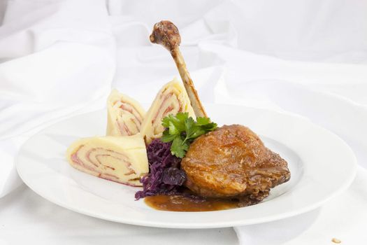 Baked duck leg with potato ham rolls and red cabbage