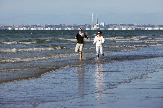 Two young women running along the beach. France