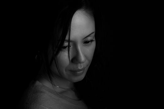 A black and white headshot of a sad looking middle aged Japanese woman.