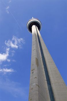 Photo og the CN Tower, blue sky, clouds and the trace of the plane