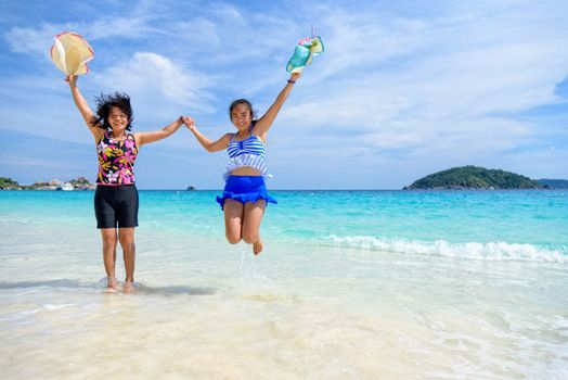 Mother and daughter wear a swimsuit playing in the blue sea near the beach with happiness during summer at Koh Miang Island, Mu Ko Similan National Park, Phang Nga province, Thailand