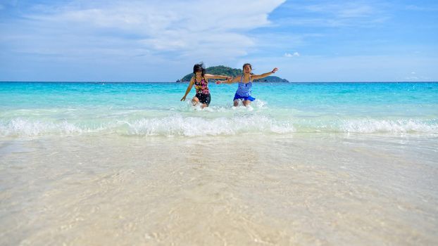 Mother and daughter in a swimsuit playing on the blue sea near the beach with happiness during summer at Koh Miang Island, Mu Ko Similan National Park, Phang Nga, Thailand, 16:9 widescreen