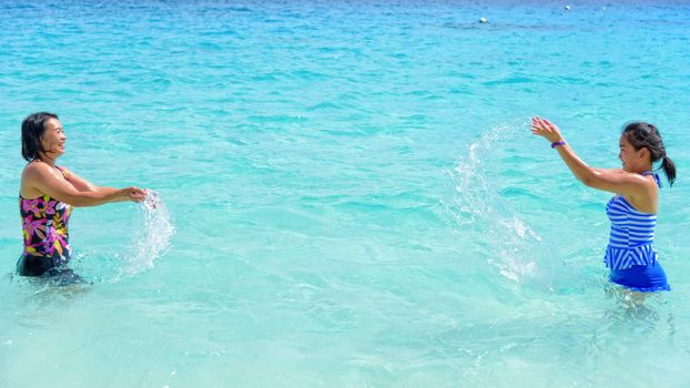 Mother and daughter in a swimsuit playing on the blue sea near the beach with happiness during summer at Koh Miang Island, Mu Ko Similan National Park, Phang Nga, Thailand, 16:9 widescreen