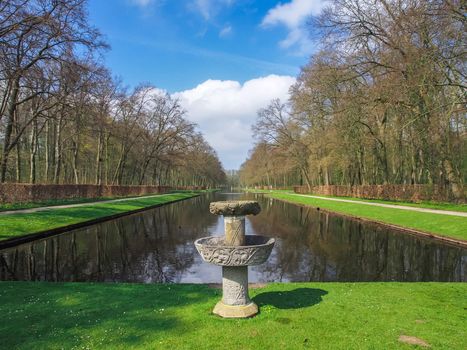 Stone fountain by the beautiful pond in the park of Kasteel De Haar