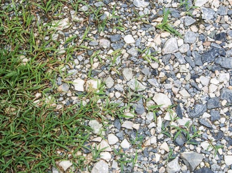 wet stones ground of parking area with grass . use for background