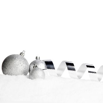 Beautiful various silver christmas decor on snow close-up