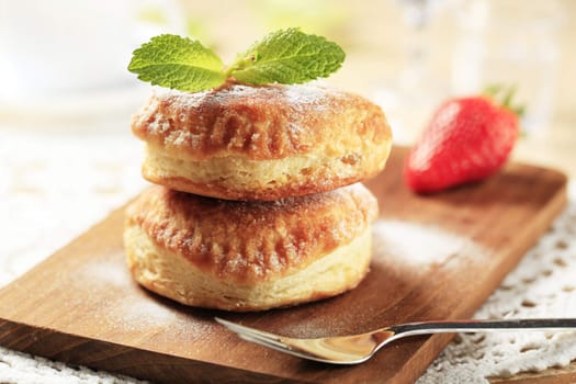 Two jam filled donuts on a cutting board