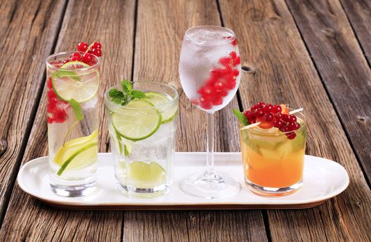 Glasses of iced drinks garnished with fresh fruit