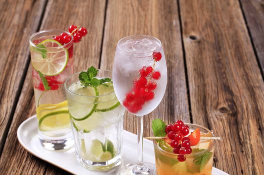 Glasses of iced drinks garnished with fresh fruit