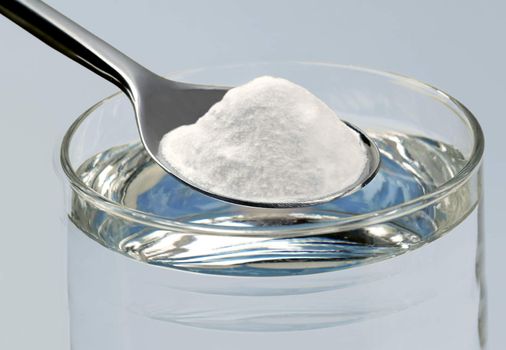 Spoon of baking soda and a glass of water
