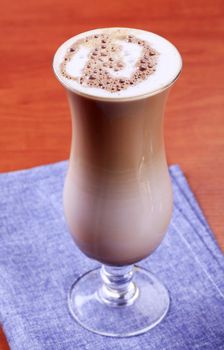 Chocolate drink with milk froth in tall glass