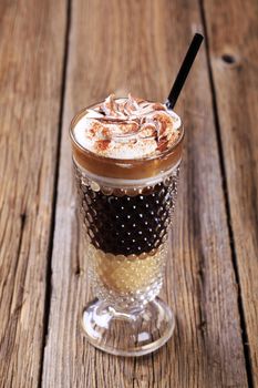 Coffee drink topped with whipped cream and mutmeg