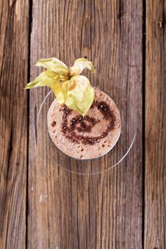 Glass of chocolate smoothie garnished with fresh fruit