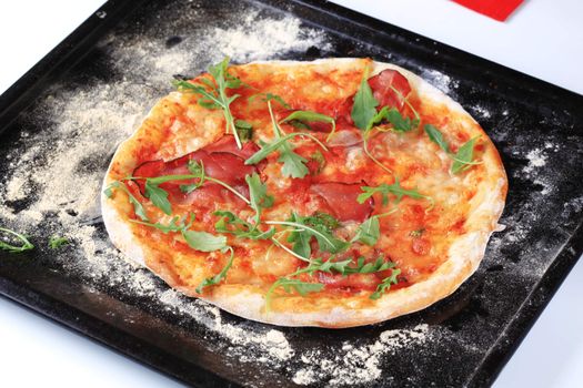 Freshly baked pizza on a baking tin