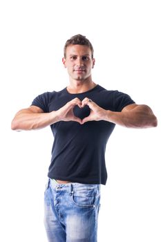 Handsome young man making heart sign with his hands and fingers. Studio shot isolated
