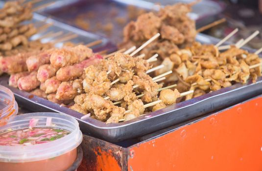 Meat balls, sausages and other meats, barbequed and sold on stick from a food stall in General Santos City, The Philippines. Shallow depth of field with only the nearest food in focus.