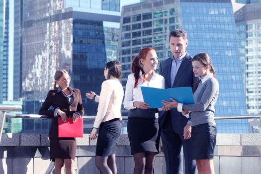 Portrait of business team outside office on skyscrapers background