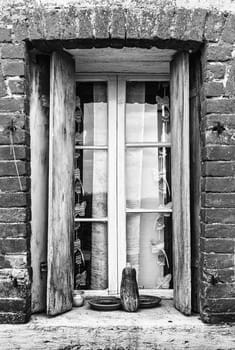Window of a farmhouse with wooden balconies and red brick frame.