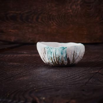 Ceramic tea cup, loose tea leaf on wood table