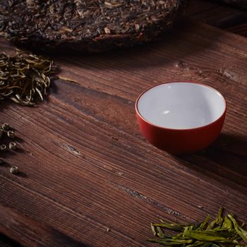 Ceramic tea cup, loose tea leaf on wood table