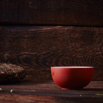 Ceramic tea cup, loose tea leaf on wood table