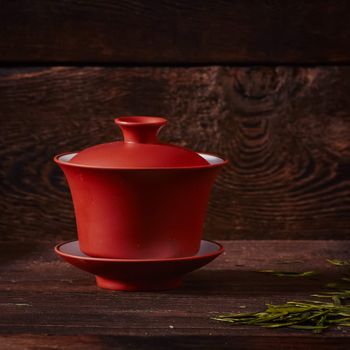 Ceramic tea cup, loose tea leaf on wood table