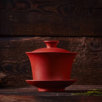 Ceramic tea cup, loose tea leaf on wood table