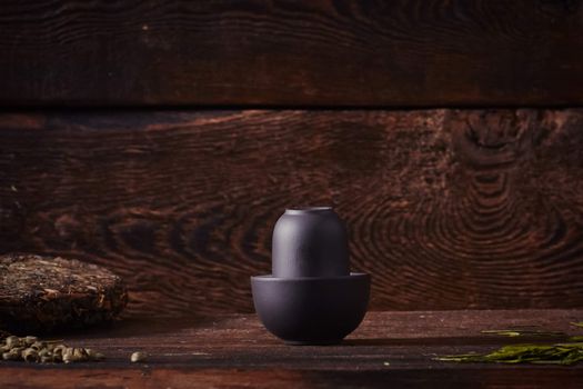 Ceramic tea cup, loose tea leaf on wood table