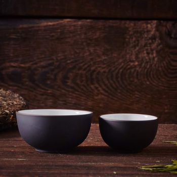 Ceramic tea cup, loose tea leaf on wood table