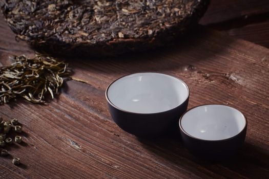 Ceramic tea cup, loose tea leaf on wood table