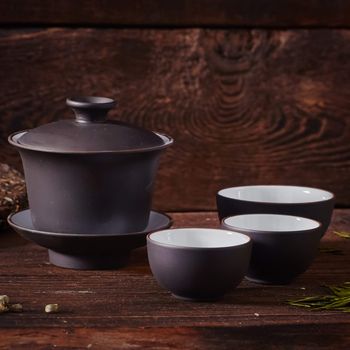 Ceramic tea cup, loose tea leaf on wood table