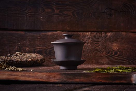 Ceramic tea cup, loose tea leaf on wood table